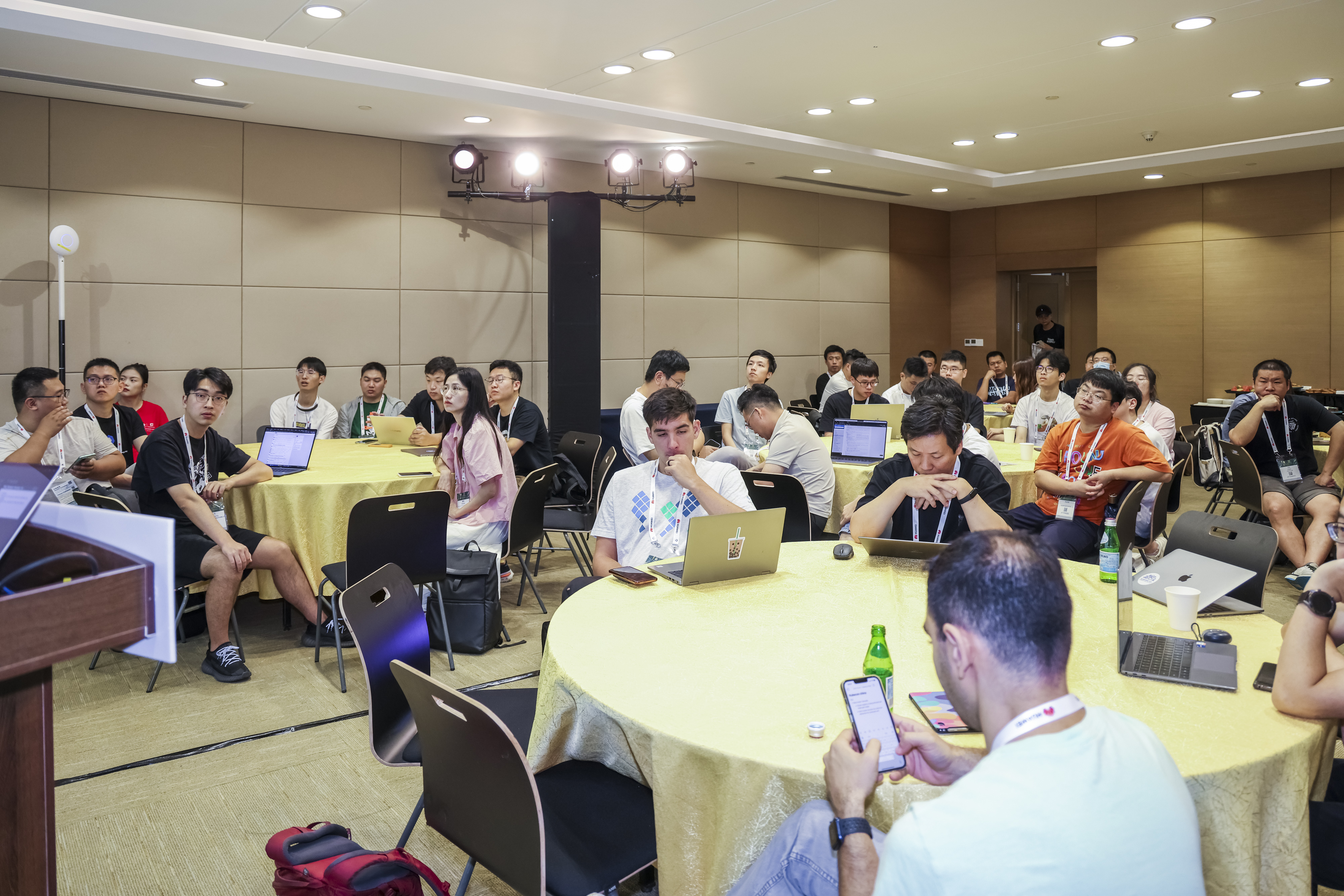 A group of Kubernetes contributors sat around circular tables